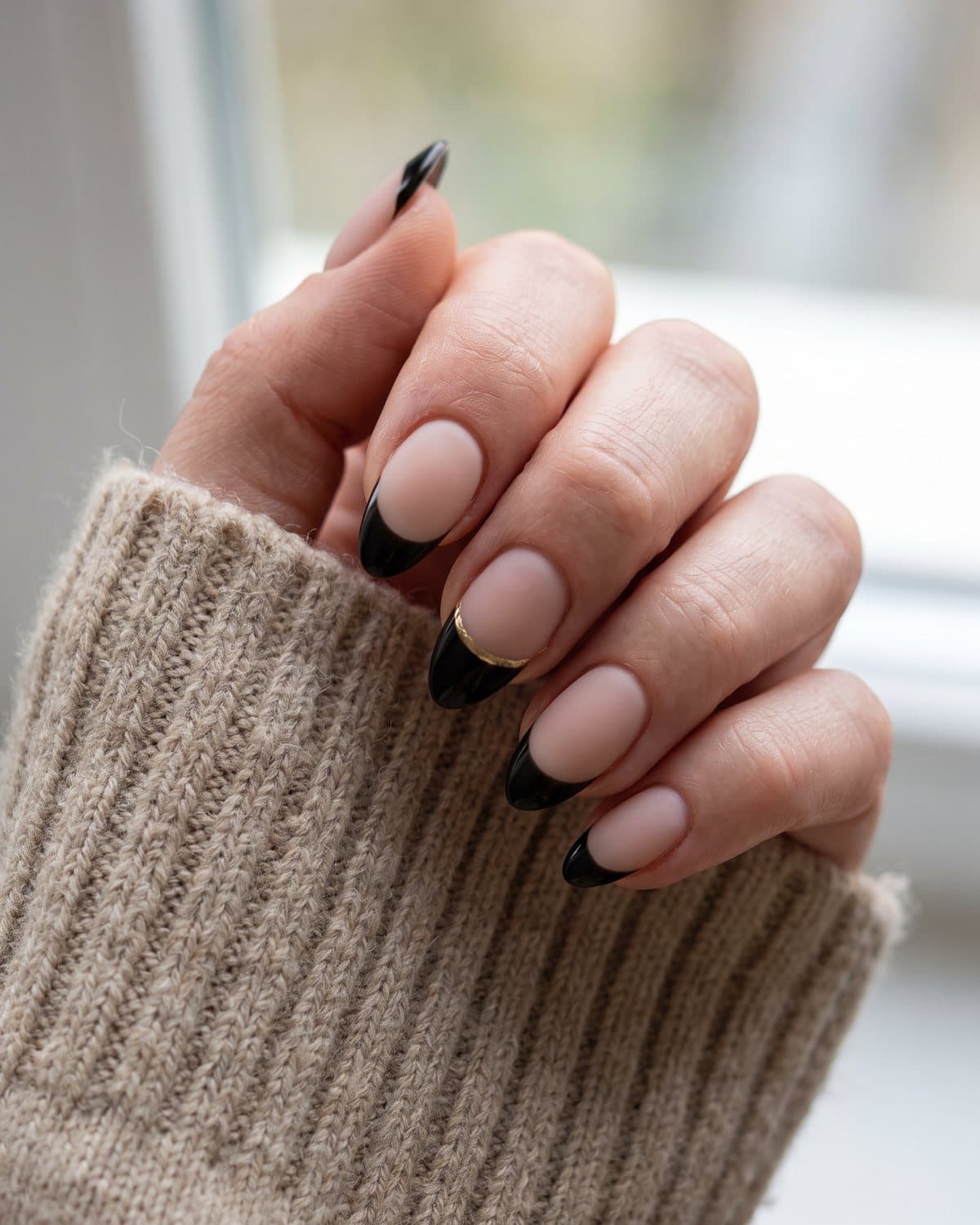 Almond nails with ultra-thin black micro French tips, black tips with a fine gold line beneath and matte nude nails with glossy black tips