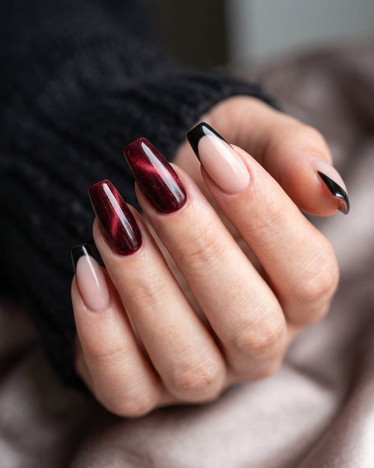 Oxblood velvet coffin nails mixed with black French tips on a dark background
