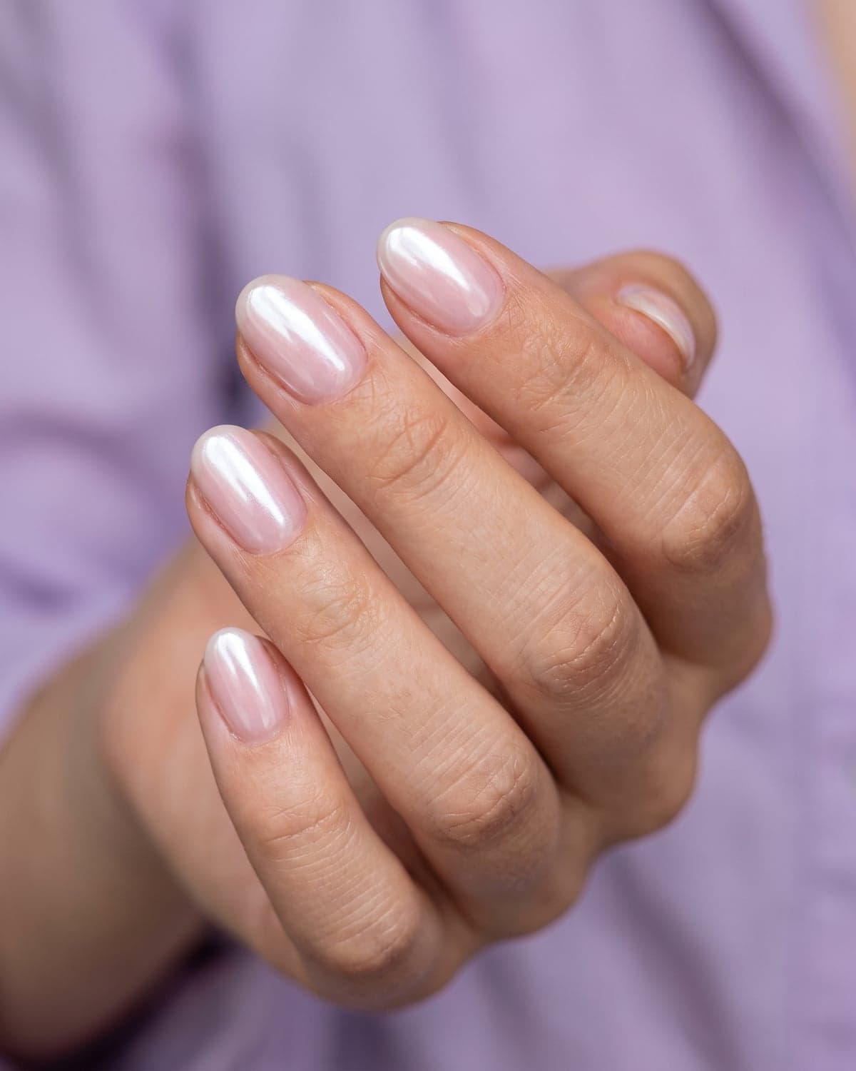 Glazed donut short oval nails with a pearly finish on a soft lilac background